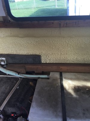 Wood under window and foam insulation.  The big piece of wood at bottom is the only structural piece and it holds the couch, but we're using it to hold the new luan.